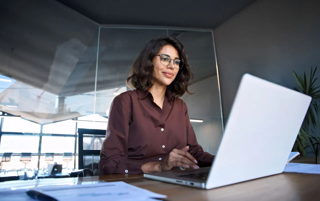 Como obter o e-CPF e o e-CNPJ? | Foto de uma mulher trabalhando no escritório em seu computador | Certificação Digital | Blog da Certisign