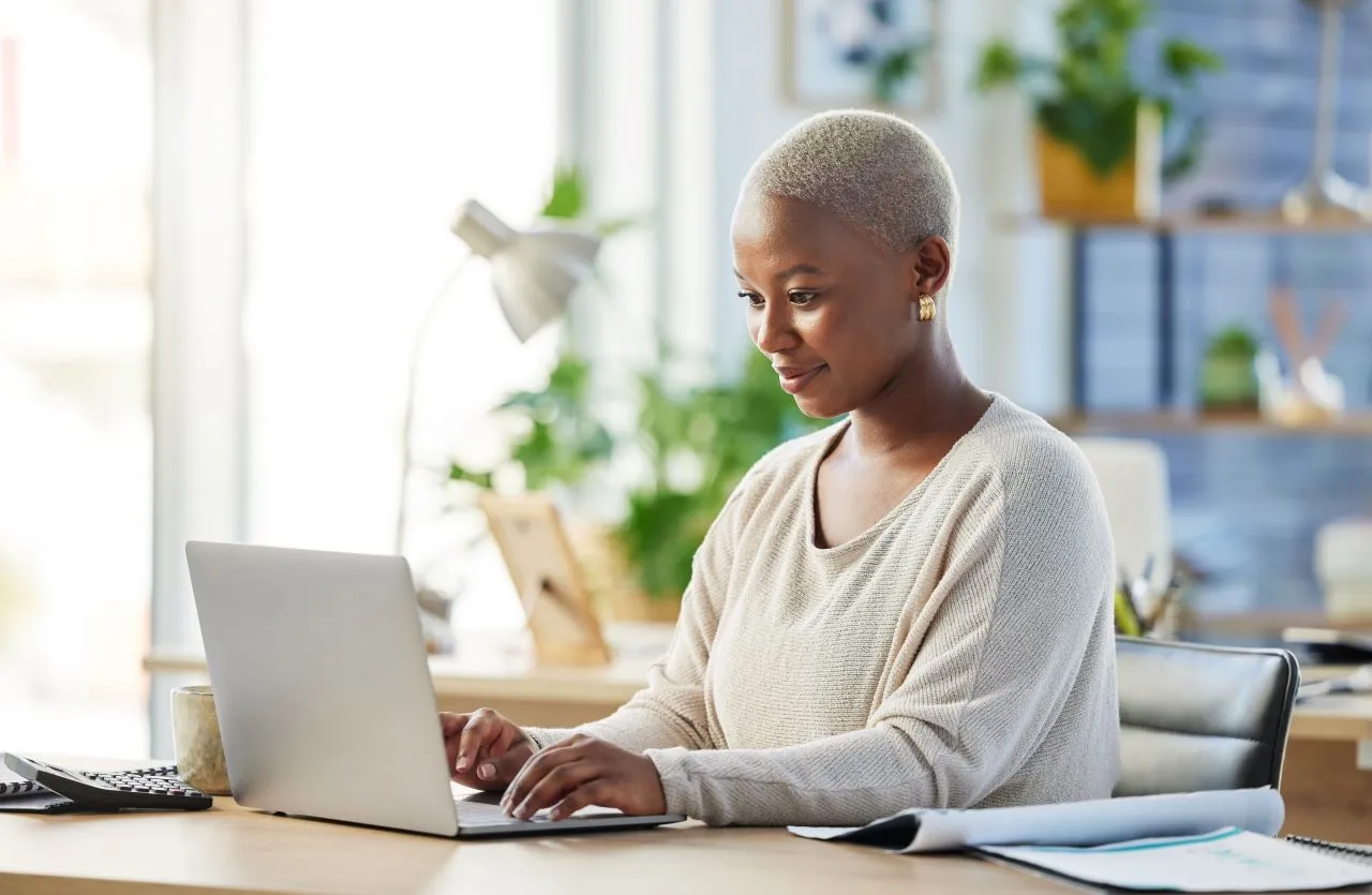 Quais as principais deduções no IRPF? | Foto de uma mulher negra fazendo a declaração do imposto de renda | Certificação Digital | Blog da Certisign