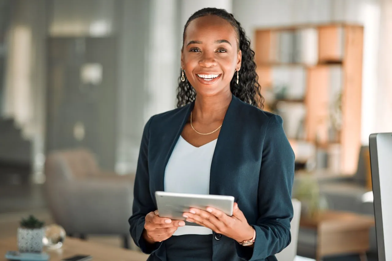 Projudi para advogados: como adquirir o certificado digital OAB | Foto de uma jovem advogada negra com um tablet na mão sorrindo | Certificação Digital | Blog da Certisign
