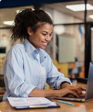 Imagem de uma jovem mulher negra com estilo casual trabalhando feliz no notebook | Certificação Digital | Certisign