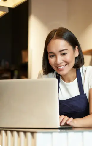 Imagem de uma jovem mulher asiática com estilo casual trabalhando feliz no notebook | Certificação Digital | Certificado SSL | Certisign