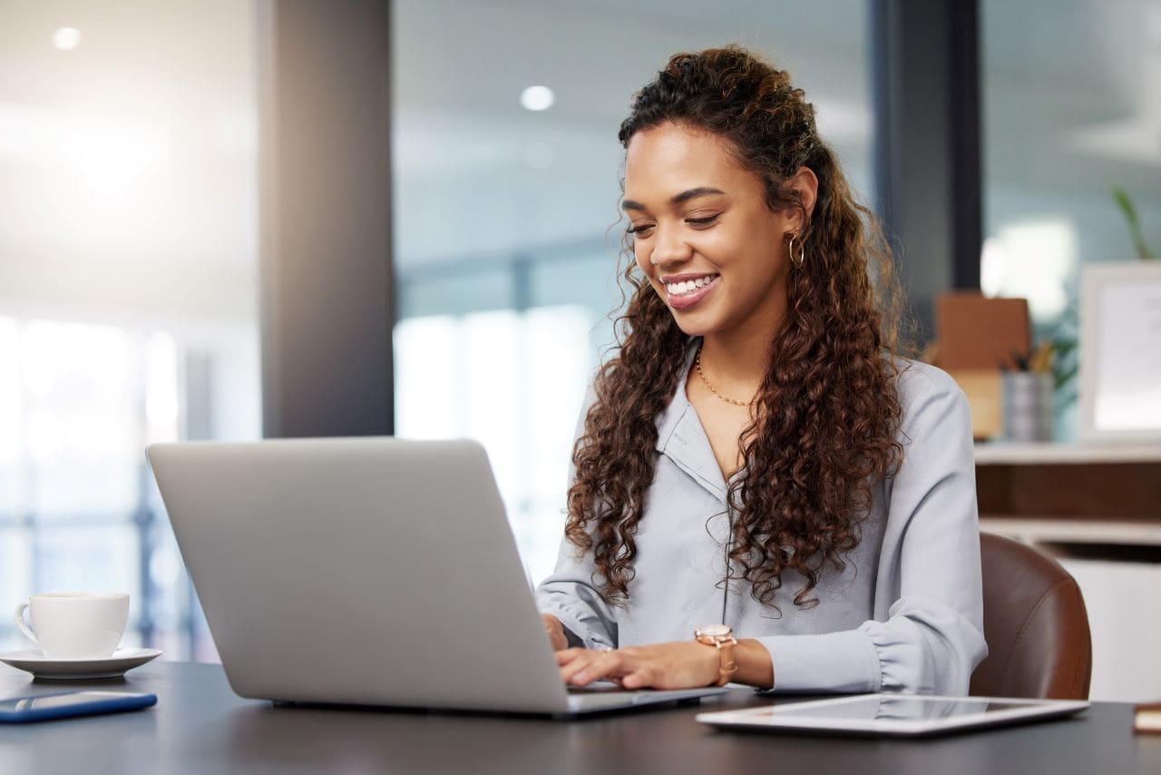 Como fazer o certificado digital do CNPJ? | Foto de uma mulher trabalhando no escritório no notebook | Certificação Digital | Blog da Certisign