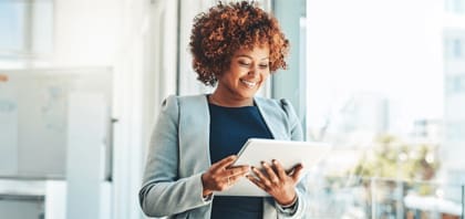 Foto de uma mulher com um tablet na mão acessando a matéria no blog