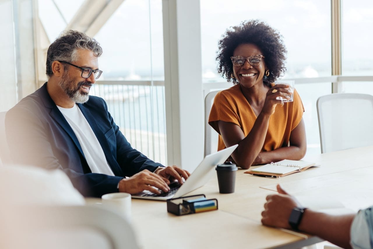 Quem precisa de um certificado digital? | Foto de um homem grisalho e uma mulher negra numa reunião de trabalho | Certificação Digital | Blog da Certisign