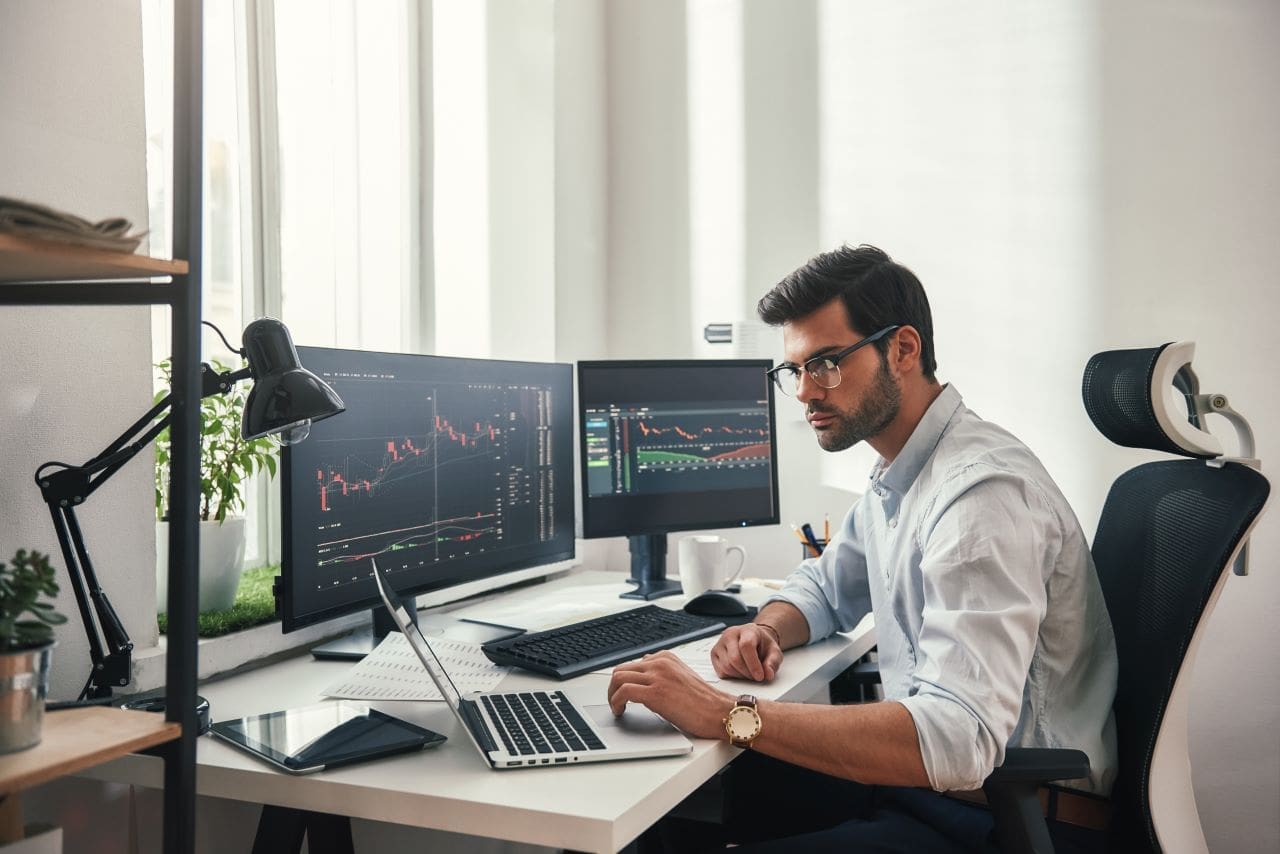 Quem deve declarar ações no Imposto de Renda? | Foto de um homem trabalhando como day trade | Certificado Digital | Imposto de Renda | Blog da Certisign