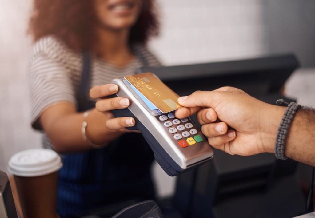 São Paulo: NFC-e obrigatória exige certificado digital e-CNPJ A1 | Foto de uma pessoa pagando no débito no caixa de uma cafeteria | Certificado Digital | Cupom Fiscal | Blog da Certisign