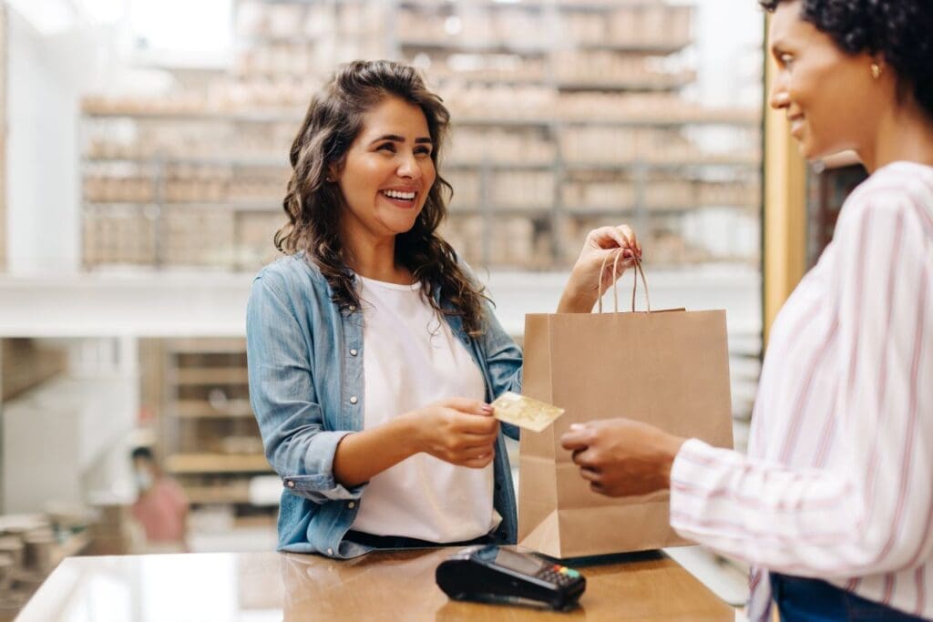 O que é NFC-e? | Foto de uma mulher pagando suas compras no caixa de uma loja | Certificado Digital | Cupom fiscal | Blog da Certisign