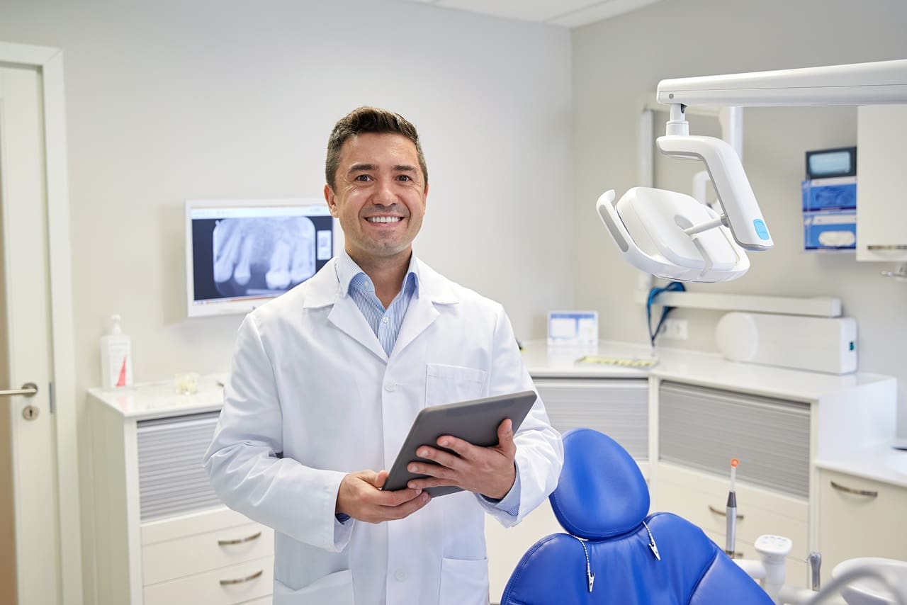 O que é a assinatura digital para dentistas? | Foto de um dentista assinando receita médica digital na clínica odontológica | Profissionais da Saúde | Blog da Certisign